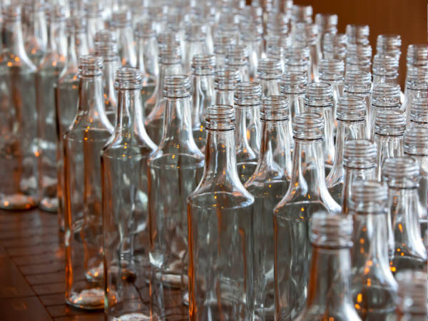 A conveyor belt full of glass bottles, which offer superior barrier properties compared to other packaging materials